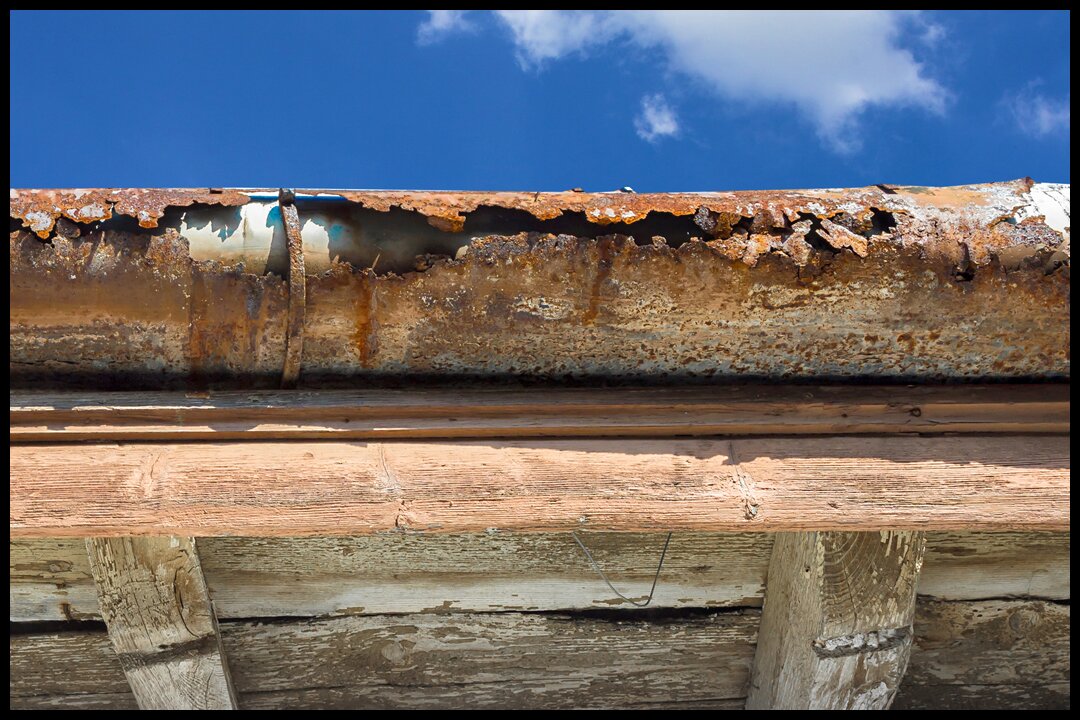 an old rusted gutter proving the importance of roof maintenance