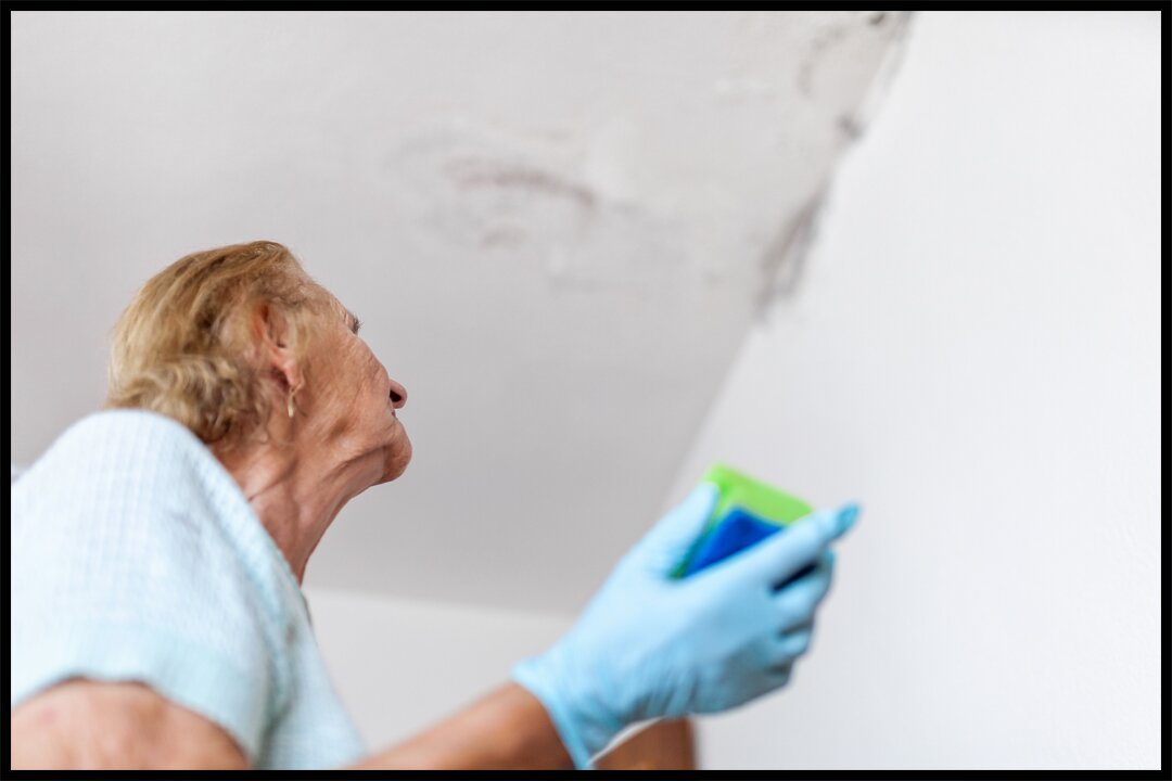 woman noticing a leak from ceiling showing one of the immediate signs you need a new roof