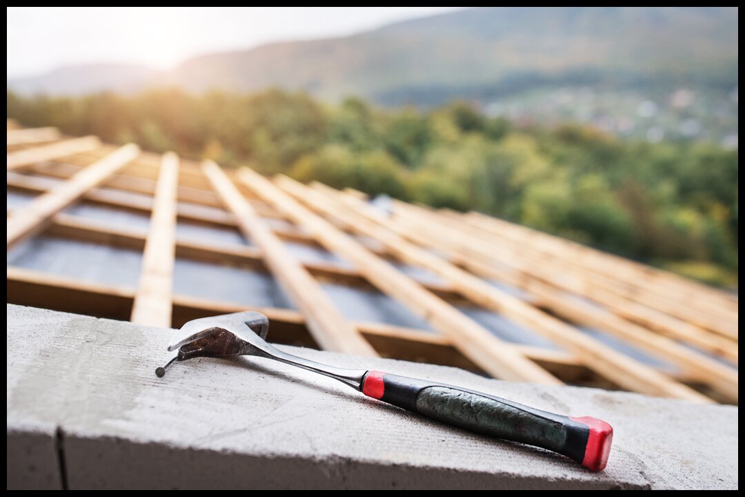 a hammer on roof to signify how to detect and patch a roof leak
