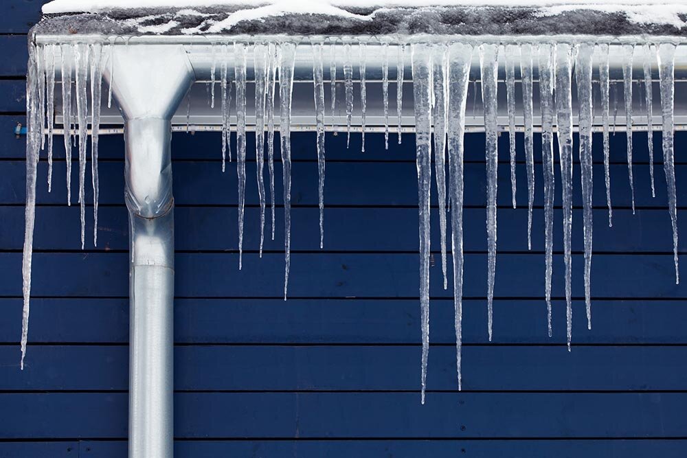 A roof gutter during the winter with ice dams.