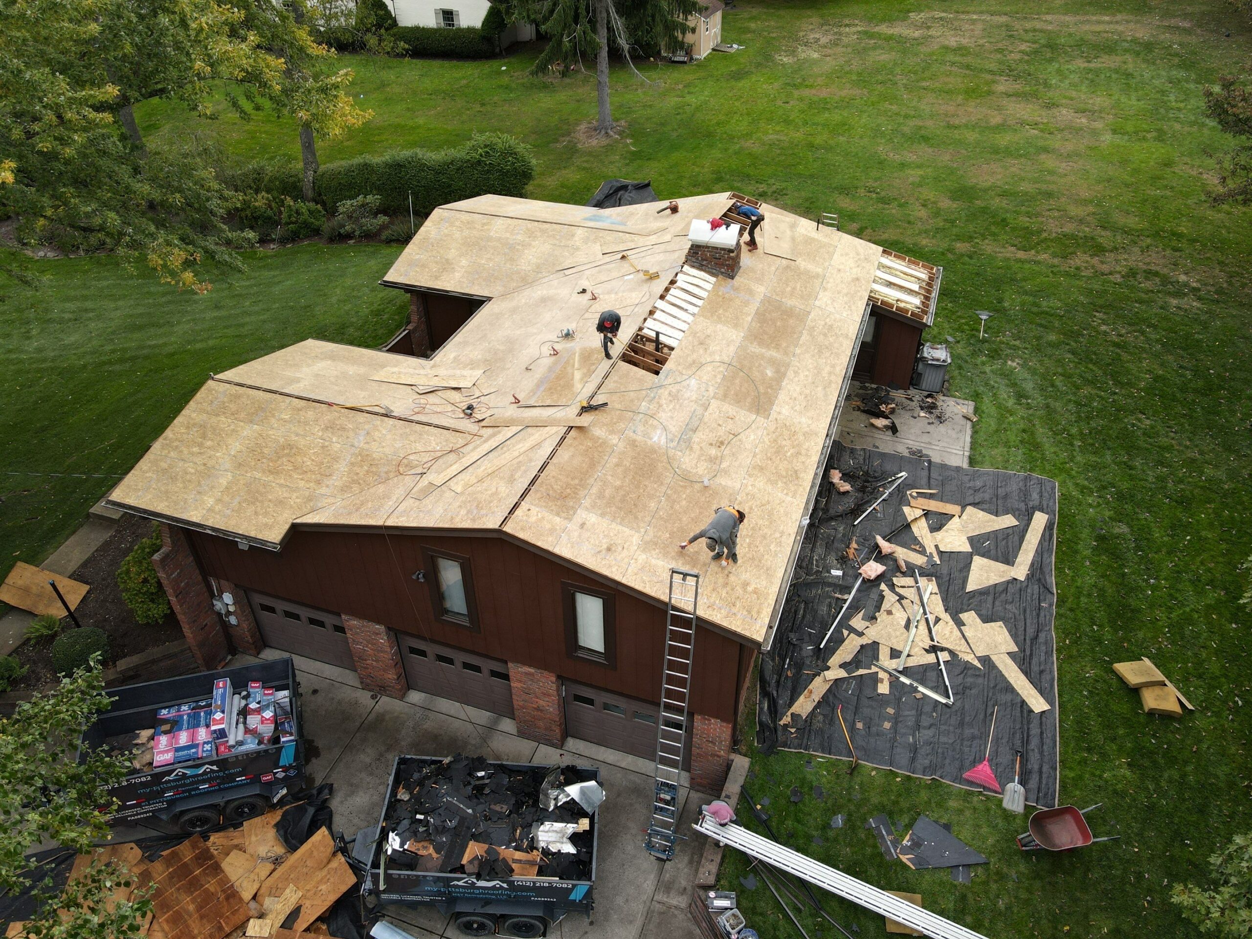 three men dismantle the roof of the house