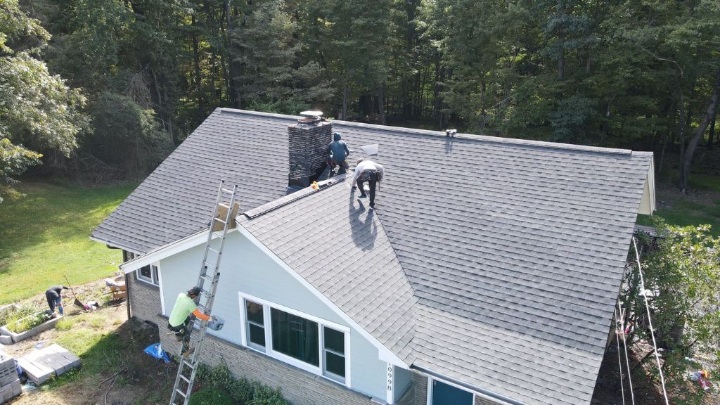 expert roofers replacing a roof on a house during the summer
