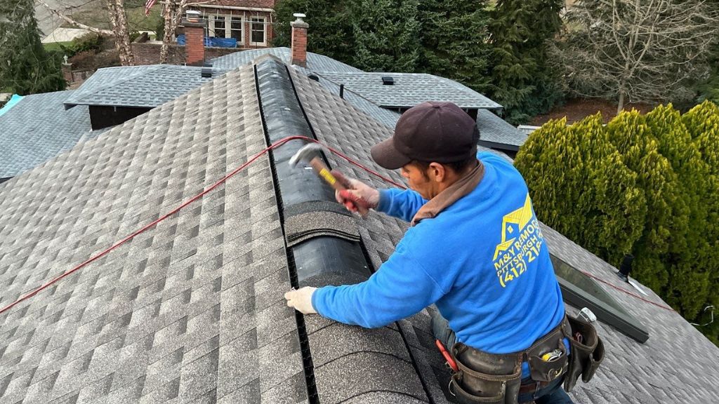 Professional roofer working on the shingles of a roof.