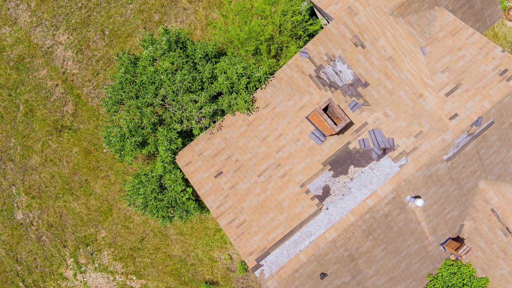 An aerial photo of a house with a damaged roof due to neglect.